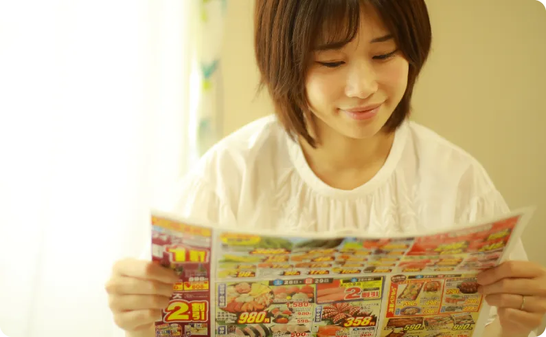 不動産チラシ.COMの住宅広告チラシを読む女性のイメージ