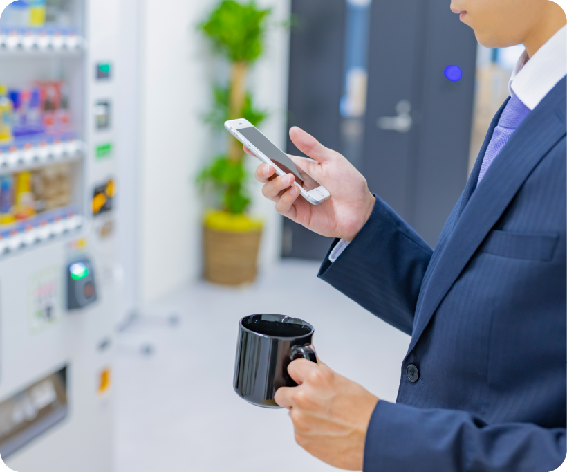 reQruの採用LPテンプレートページ2の自販機前でアイスブレイクする男性社員